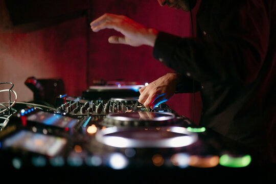 Close up view of a dj's hands playing the mixer while performing