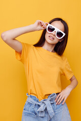 Fototapeta premium attractive woman fashion in yellow t-shirt denim shorts yellow background