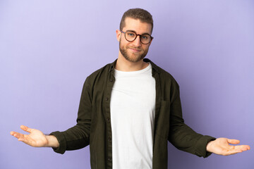 Young handsome caucasian man isolated on purple background having doubts