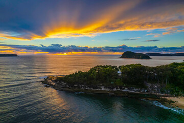 Fototapeta premium Aerial sunrise seascape with overcast sky and rain clouds