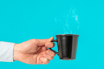 Hand of a man holding a hot coffee cup