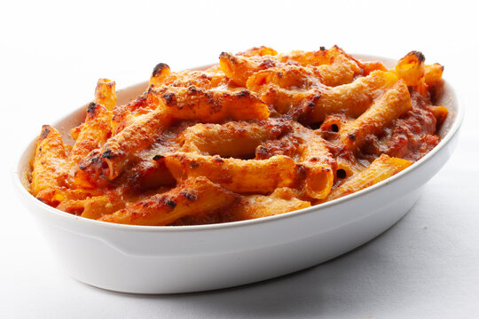 De cerca macarrones con tomate y queso al horno sobre fondo blanco. Close up baked macaroni tomato and cheese on white background.