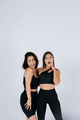 Two young women posing over white background.