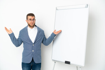 Young business woman giving a presentation on white board isolated on white background having doubts while raising hands