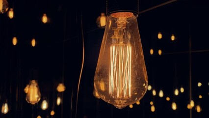 Flickering old fashion tungsten Edison light bulb lamp over black background. Slow motion shot 4K. - Powered by Adobe