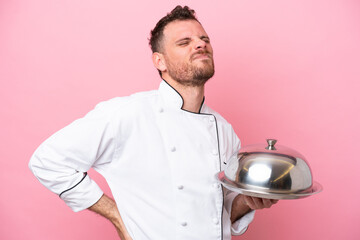 Young Brazilian chef with tray isolated on pink background suffering from backache for having made an effort