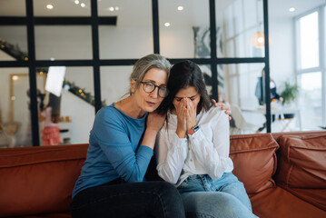 Fototapeta premium Grandmother comforting her sad granddaughter at home.