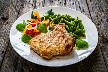 Grilled steak with boiled green bean on wooden table 