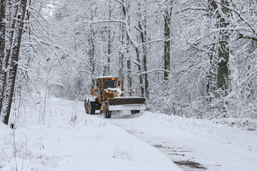Large old snow truck driving towards camera on a winter environment.