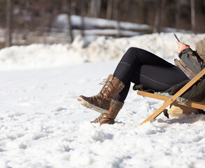 Person sitzt im Schnee auf einen Sessel 