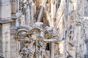 Medieval gothic gargoyle statue on the roof top of the cathedral of Milan, Lombardy, Italy