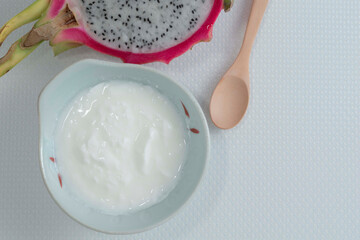 Healthy food yoghurt in bowl has fruit on white table.