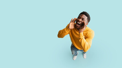 Cheerful black guy saying something out loud, copy space