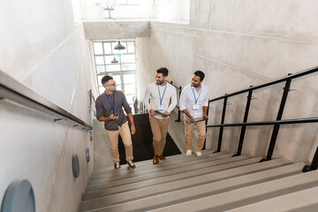 business, people and corporate concept - group of men with conference badges, folder, tablet pc...