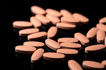 Close up of Multi Vitamin tablet on a reflective black background