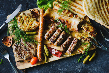 Assorted sausages, bacon and grilled meat with spices, pickles and flatbread. Serbian chevapchichi. 