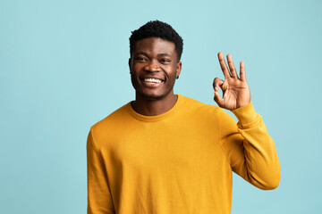 Cheerful african american guy showing okay gesture