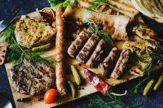 Assorted sausages, bacon and grilled meat with spices and flatbread. Serbian chevapchichi. Cuisine and serving in the restaurant