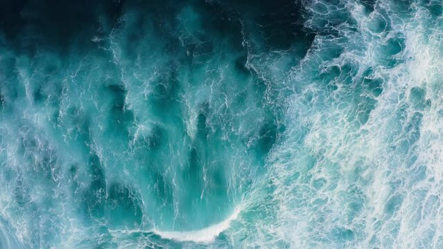 Beautiful texture of big power dark ocean waves with white wash. Aerial top view footage of fabulous sea tide on a stormy day. Drone filming breaking surf with foam in Indian ocean. Big swell in Bali.