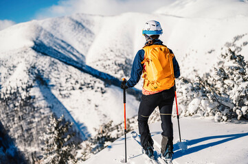 Mountaineer backcountry ski walking ski woman alpinist in the mountains. Ski touring in alpine...