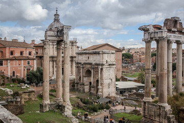 Fototapeta na wymiar View from the Capitol to the Imperial Forums, the ruins of the Basilica of Julius and the temple of Saturn and the arch of Septimius Severus. Rome, Italy
