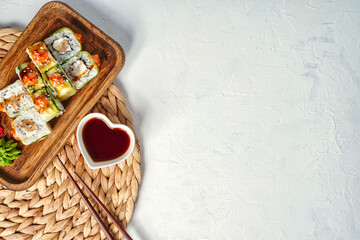 Sushi rolls covered cucumber with fresh fish and copy space for text.