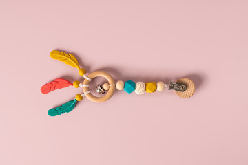 Baby Silicone Teething Toy and Pacifier Holder on Pink Background