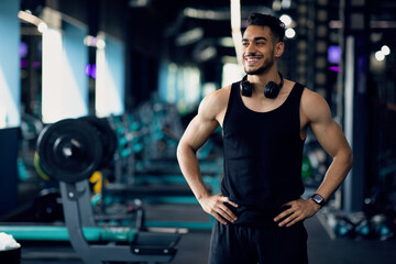 Fototapeta na wymiar Gym Advertisement. Portrait Of Handsome Sporty Arab Man Posing In Fitness Club