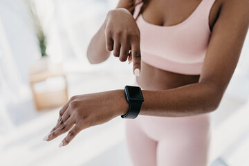 Fototapeta premium Unrecognizable young black woman pointing at fitness tracker with mockup, having workout break, checking heart rate