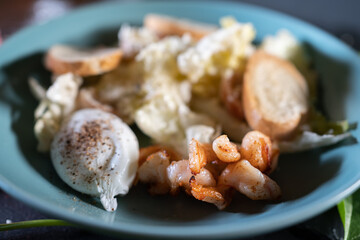 fresh and delicious caesar shrimp salad with lettuce and crusty crouton toasts