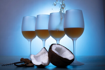 wine glasses for wine on the table on a blue background next to a coconut