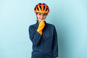 Young cyclist woman isolated on blue background thinking