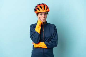 Young cyclist woman isolated on blue background thinking an idea