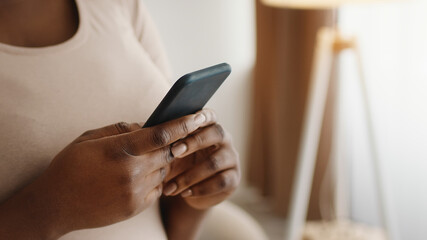 Cellphone in black female hands, unrecognizable african american woman web surfing in social media on mobile appe