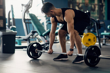 Fototapeta na wymiar Portrait Of Muscular Middle Eastern Guy Making Deadlift Workout At Modern Gym