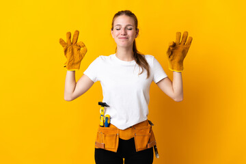 Young electrician woman isolated on yellow background in zen pose