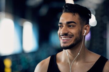 Portrait Of Happy Sporty Middle Eastern Guy Wearing Earphones At Gym