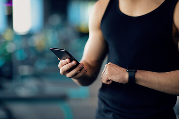 Unrecognizable Sporty Man Synchronizing Information Between Smartphone And Smartwatch, Closeup
