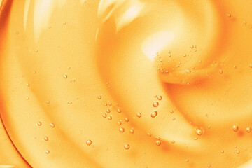 Orange gel texture background. Gold cosmetic transparent cream swirl with bubbles. Citrus fruit skincare product closeup - obrazy, fototapety, plakaty