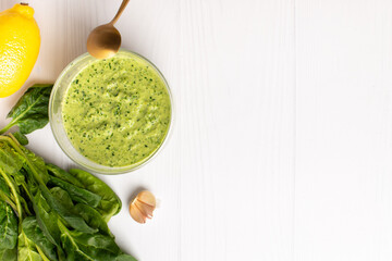 spinach sauce with lemon and garlic on a white background