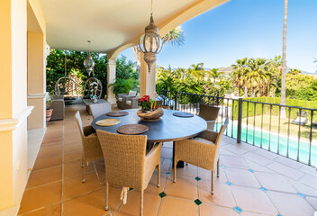 a view overlooking a villa pool from the dining terrace area with blue skies 