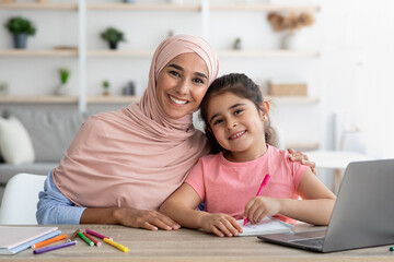 Home Portrait Of Happy Muslim Woman In Hijab And Her Little Daughter