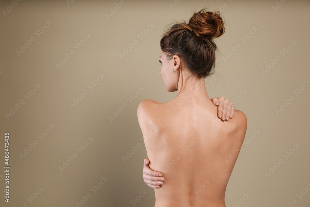 Sticker Back view of woman with perfect smooth skin on beige background, space for text. Beauty and body care