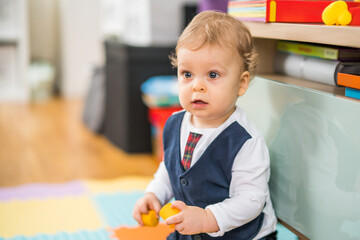 Portrait of cute little baby boy playing.