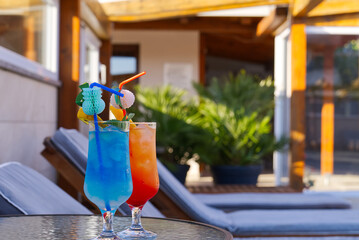 Blue Lagoon Beach Cocktail and Sex on the beach Cocktail in front of a blue swimming pool. summer cocktail with copy space