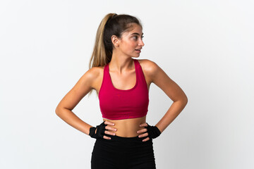 Young caucasian woman isolated on white background posing with arms at hip and looking side