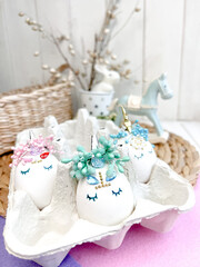Festive Easter table setting with painted unicorn eggs and floral decor on light background