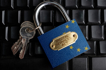 Digital services act (DSA) concept: lock and keys with European Union Flag over a black computer...