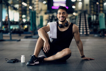 Young Arab Male Athlete Relaxing On Floor After Training At Gym