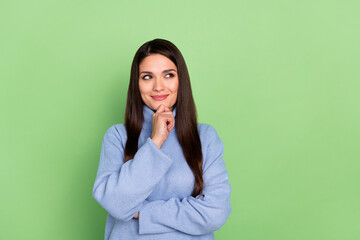 Photo of charming dreamy mature lady dressed blue pullover arm chin looking empty space smiling isolated green color background